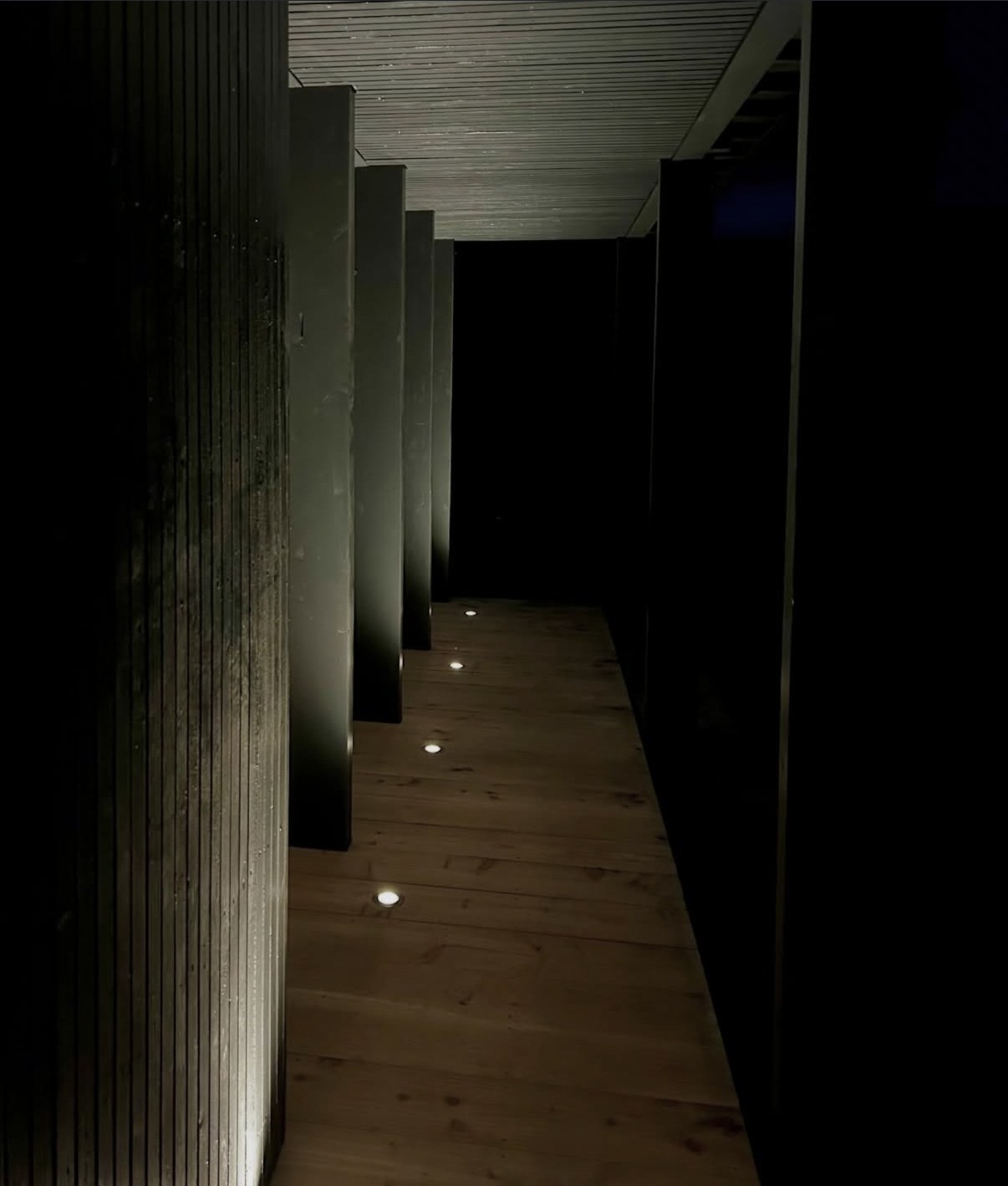 Maison noire contemporaine en bois — matière et contrastes révélés la nuit